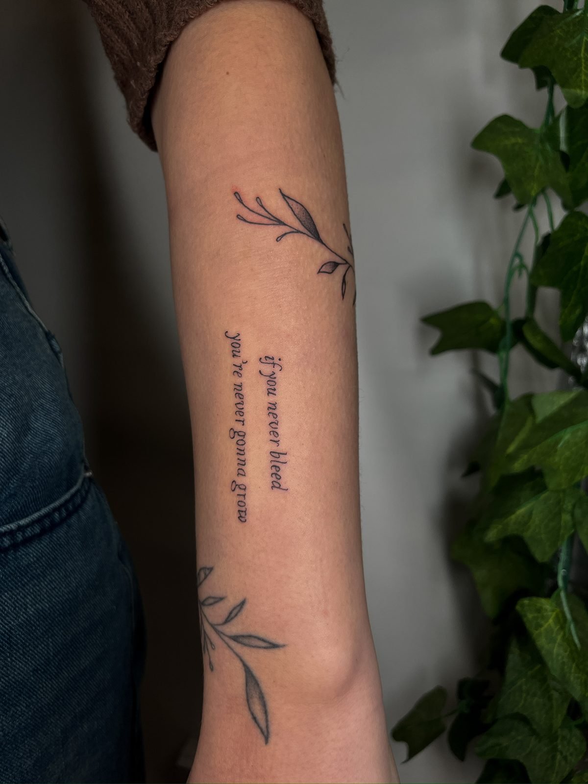 Tatuaje fine line de ramas con frase